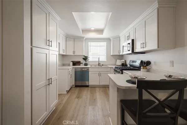 a kitchen with cabinets stainless steel appliances and a window