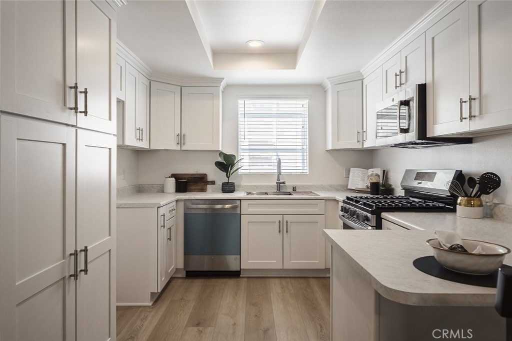 26941 Rainbow Glen Drive, Unit 751 Santa Clarita, CA 91351 - Photo 5 of 34 a kitchen with stainless steel appliances granite countertop a sink stove and refrigerator