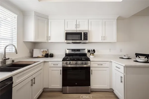 a kitchen with white cabinets and appliances