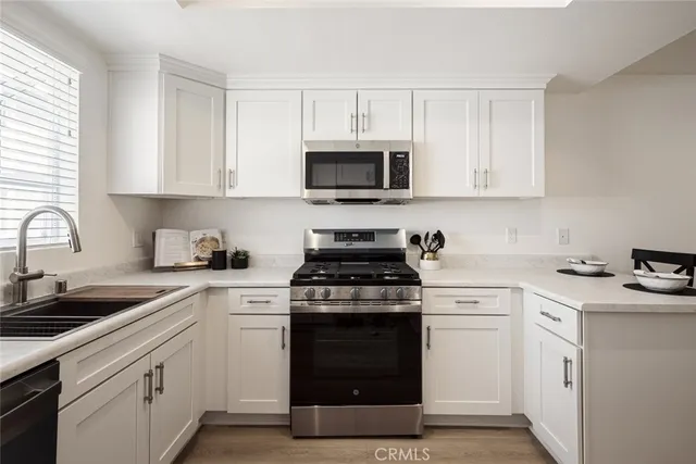 a kitchen with white cabinets and appliances