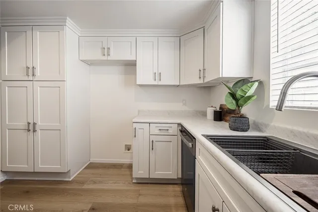a kitchen with white cabinets and appliances