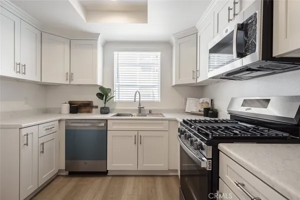 a kitchen with cabinets appliances a sink and a window