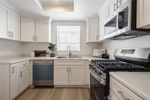 a kitchen with cabinets appliances a sink and a window