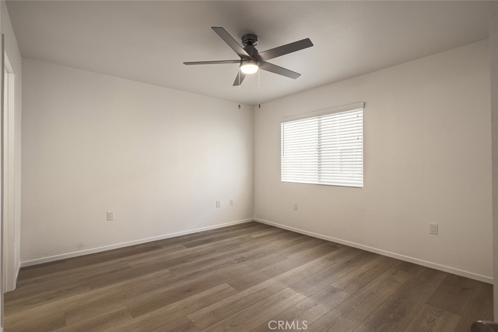 26941 Rainbow Glen Drive, Unit 751 Santa Clarita, CA 91351 - Photo 9 of 34 an empty room with wooden floor ceiling fan and windows