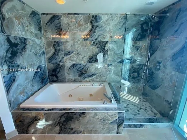 a bath tub sitting in a bathroom next to a shower