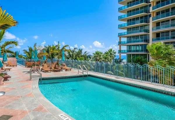 a view of a swimming pool with a patio and plants