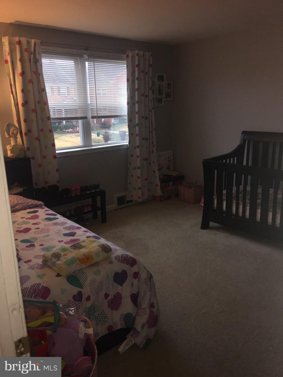 1728 Ingram Road Baltimore, MD 21239 - Photo 19 of 44 a bed sitting in a bedroom next to a window