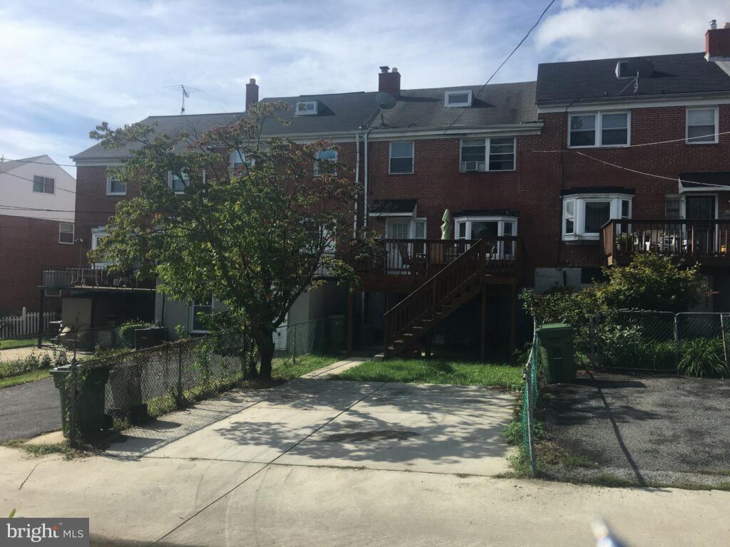 1728 Ingram Road Baltimore, MD 21239 - Photo 6 of 44 a view of a brick house with many windows next to a yard
