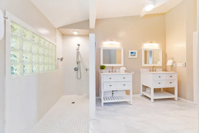 a bathroom with a tub sink shower and mirror