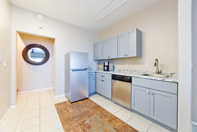 a kitchen with granite countertop a sink cabinets stainless steel appliances and a counter top space