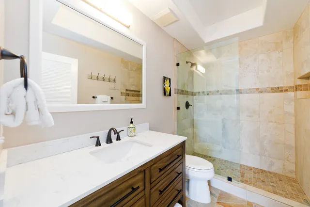 a bathroom with a sink a toilet and shower