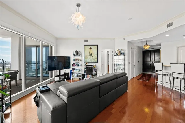 a living room with stainless steel appliances furniture a refrigerator and a kitchen
