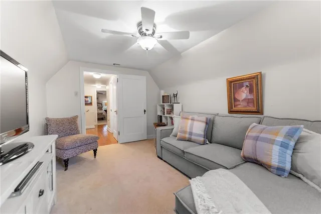 a living room with furniture flat screen tv and window