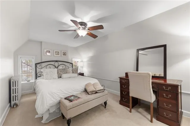 a bedroom with a white bed white walls and a chandelier