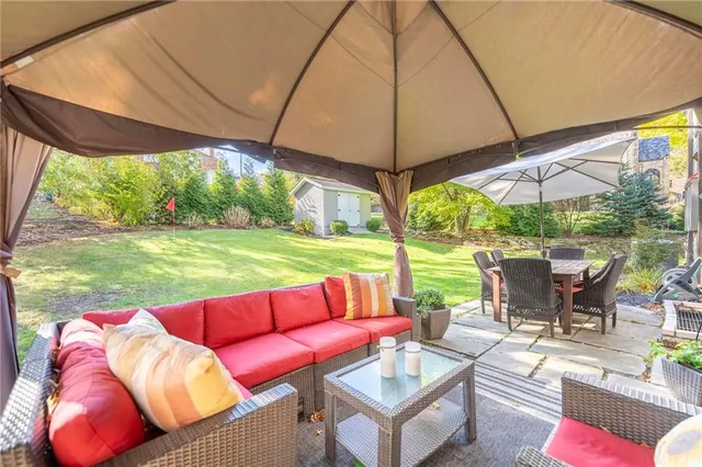 a view of a patio with table and chairs under an umbrella