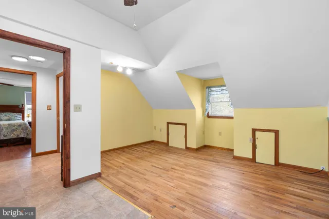 a view of a livingroom with wooden floor and a hallway