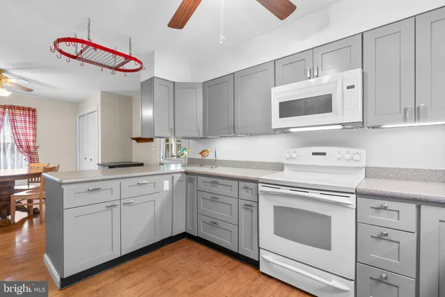 a kitchen with cabinets stainless steel appliances and wooden floor