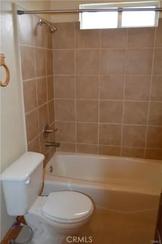 a white toilet sitting next to a bath tub and a shower