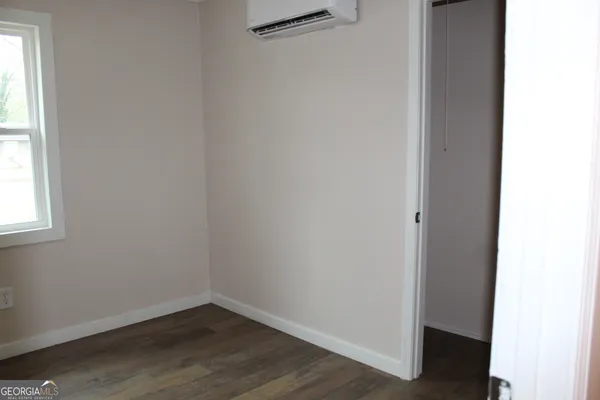 a view of a small space with wooden floor and a window