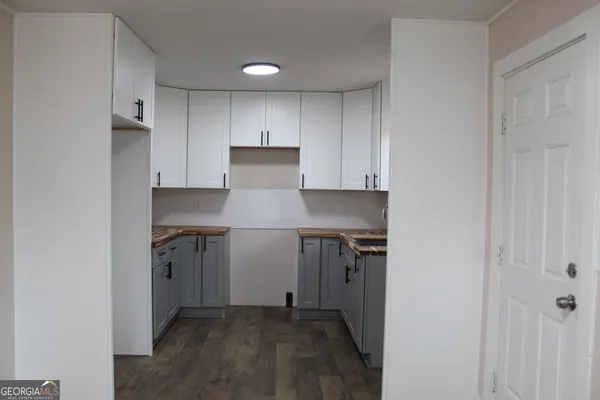 a kitchen with a refrigerator and white cabinets