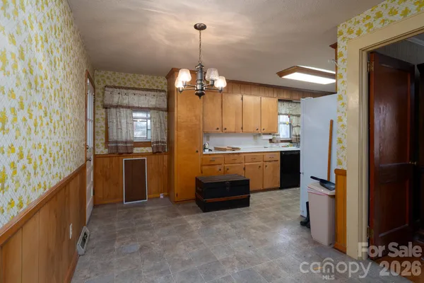 a view of a livingroom with furniture kitchen window and wooden floor