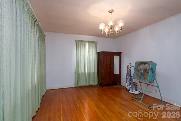 a view of a room with gym equipment and wooden floor