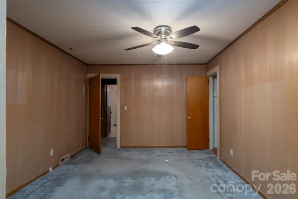 a view of an empty room with a chandelier fan