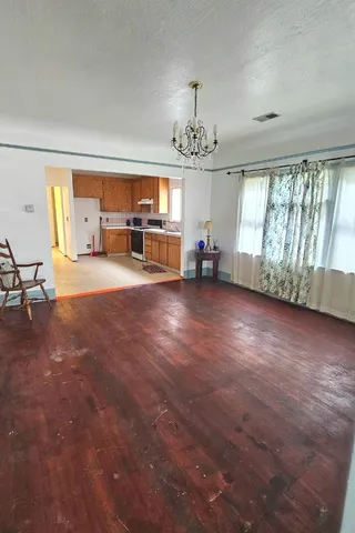a view of a livingroom with furniture wooden floor and windows