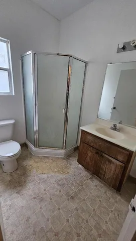 a bathroom with a sink a toilet a mirror and shower