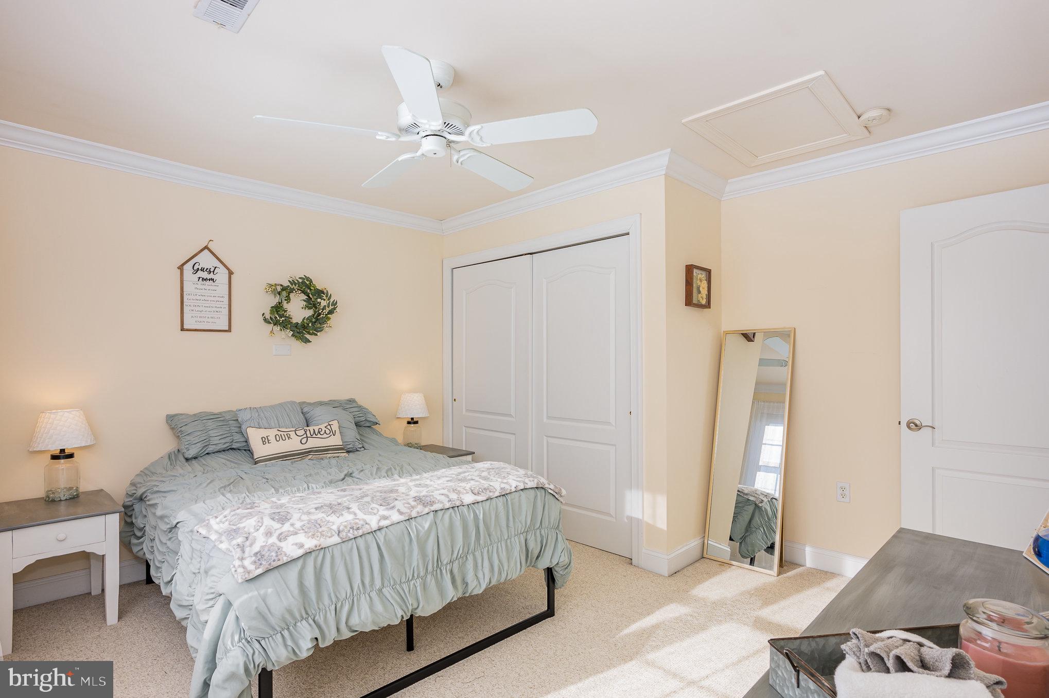 8291 Clearfield Road Denton, MD 21629 - Photo 29 of 40 a bedroom with a large bed and a chandelier