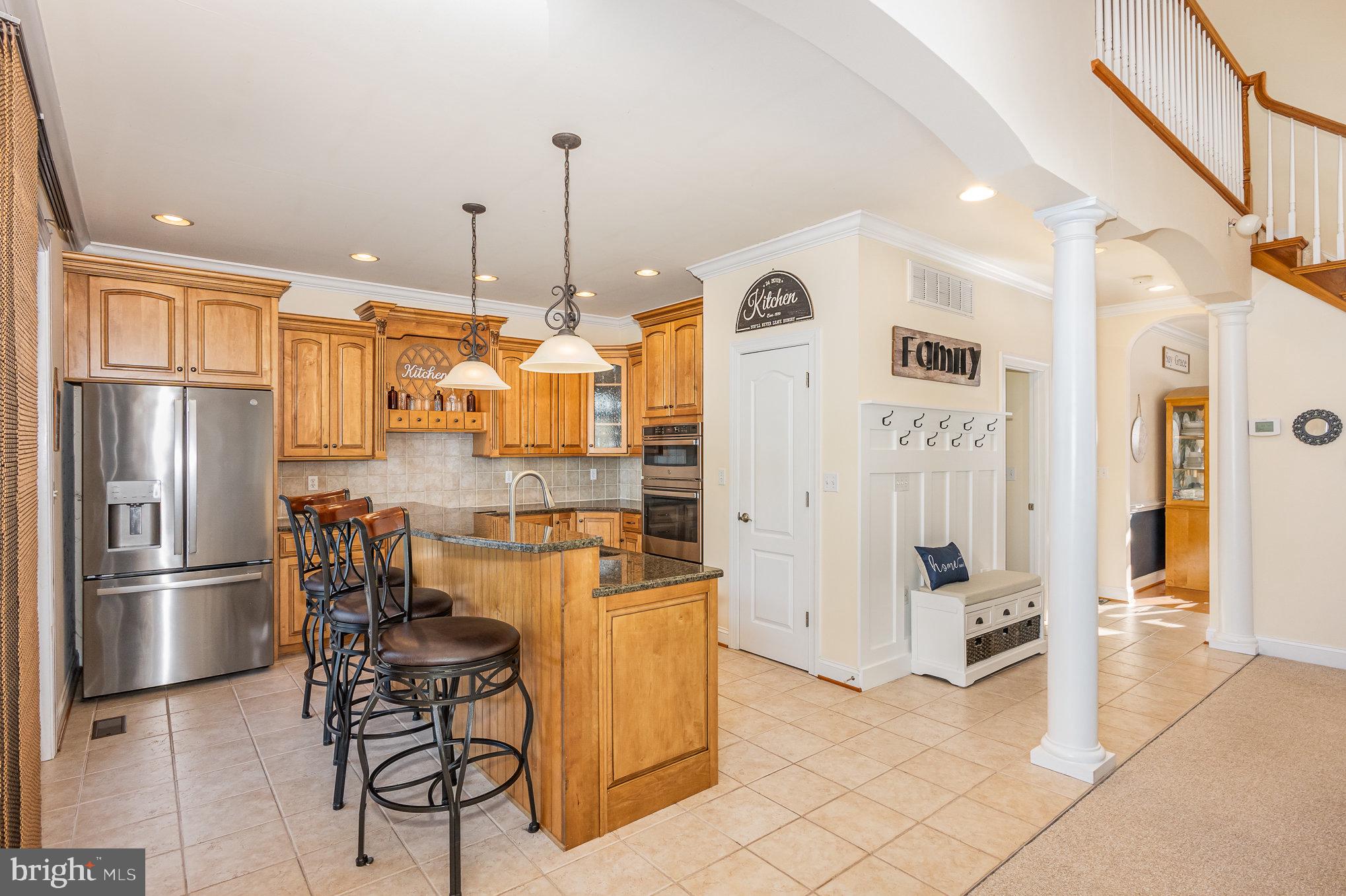8291 Clearfield Road Denton, MD 21629 - Photo 10 of 40 a kitchen with stainless steel appliances kitchen island granite countertop a refrigerator and cabinets
