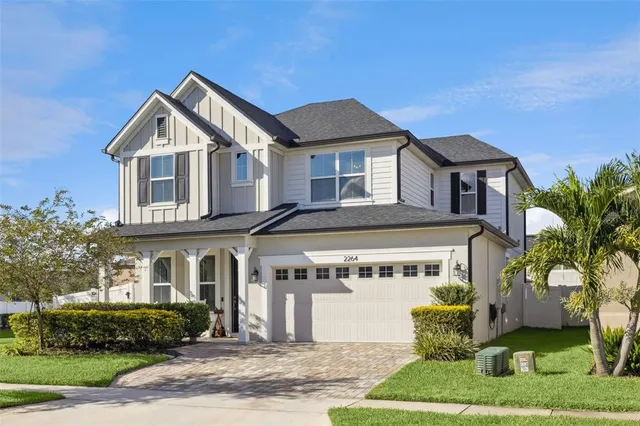 a front view of a house with a yard and potted plants