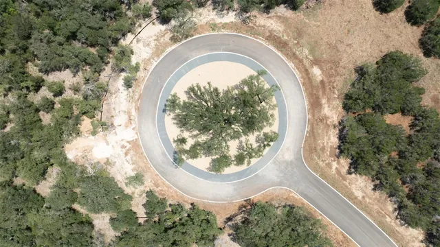 an aerial view of a house with a yard and lake