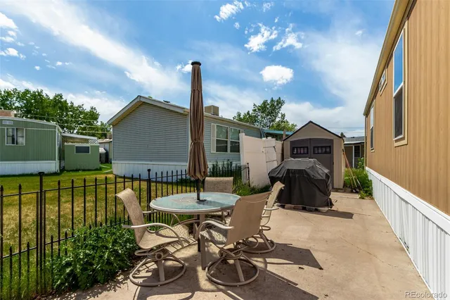 a view of a patio with table and chairs with wooden fence