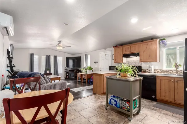 a living room with a couch a dining table and large windows