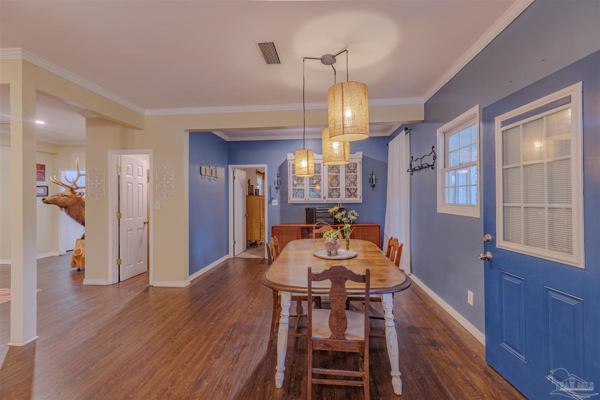 5049 Guernsey Road Pace, FL 32571 - Photo 26 of 61 a view of a dining room with furniture and wooden floor