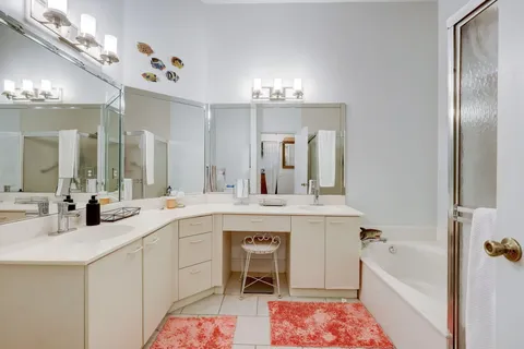 a spacious bathroom with a sink a large mirror and a bathtub