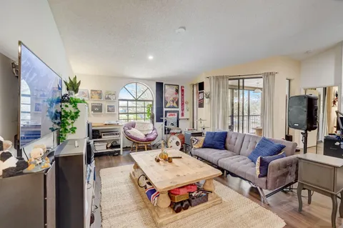 a living room with furniture a flat screen tv and a large window