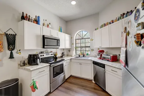 a kitchen with a sink a stove and cabinets