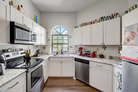 a kitchen with stainless steel appliances granite countertop a sink dishwasher a stove and a microwave oven with cabinets