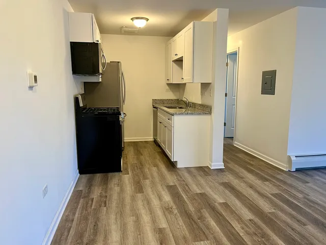 a kitchen with a refrigerator and a stove top oven