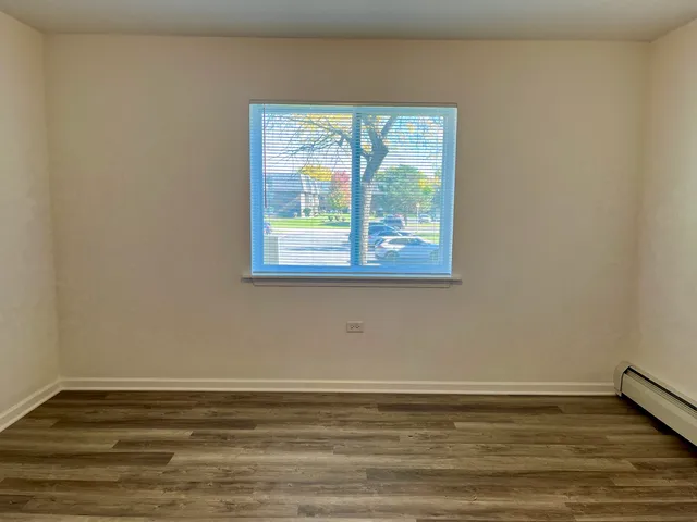 a view of a room with wooden floor and window