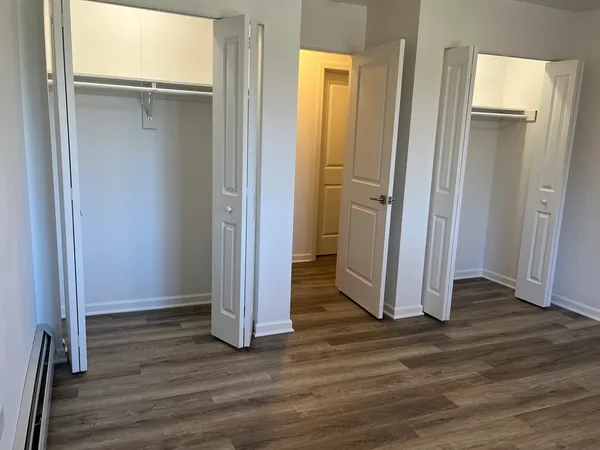 an empty room with wooden floor and a bathroom