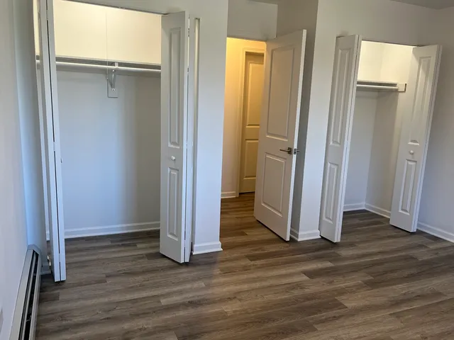an empty room with wooden floor and a bathroom