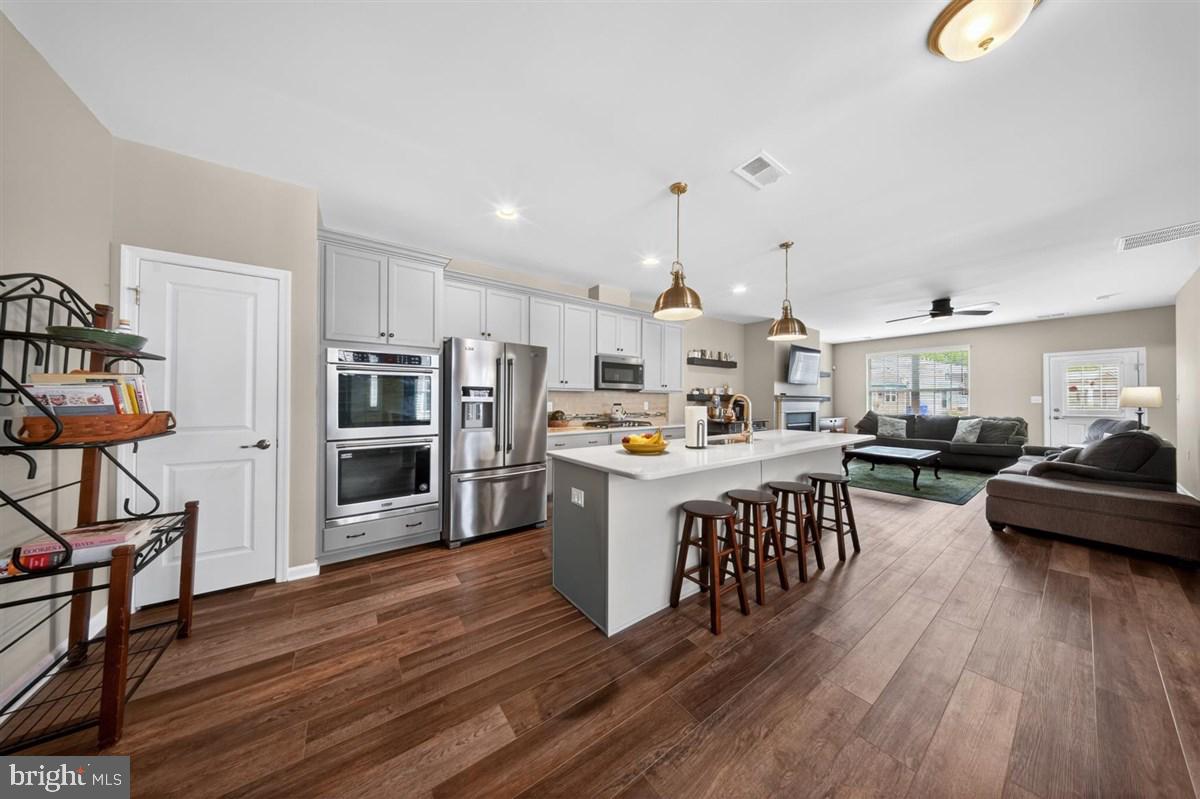 1426 Whispering Woods Road Middletown, DE 19709 - Photo 9 of 37 a open kitchen with stainless steel appliances granite countertop a lot of cabinets a sink dishwasher and a stove with wooden floor