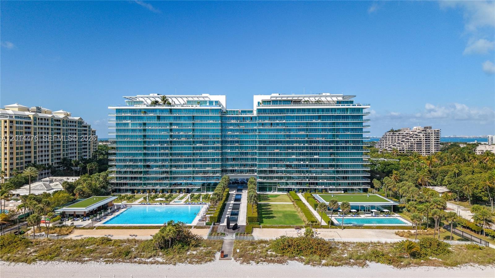 360 Ocean Drive, Unit 1106S Key Biscayne, FL 33149 - Photo 45 of 67 Aerial Exterior / Oceanfront Amenities – The property is framed by beachfront, pool areas, green spaces, and neighboring coastal residences. This view emphasizes the building’s scale, setting, and connection to the shoreline.