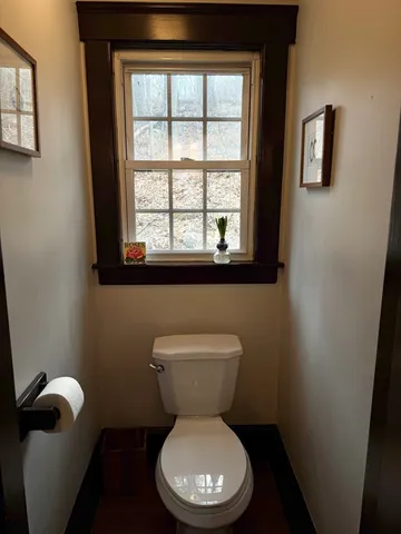 a bathroom with a toilet and a window