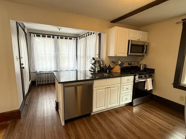 a kitchen with sink a microwave and cabinets