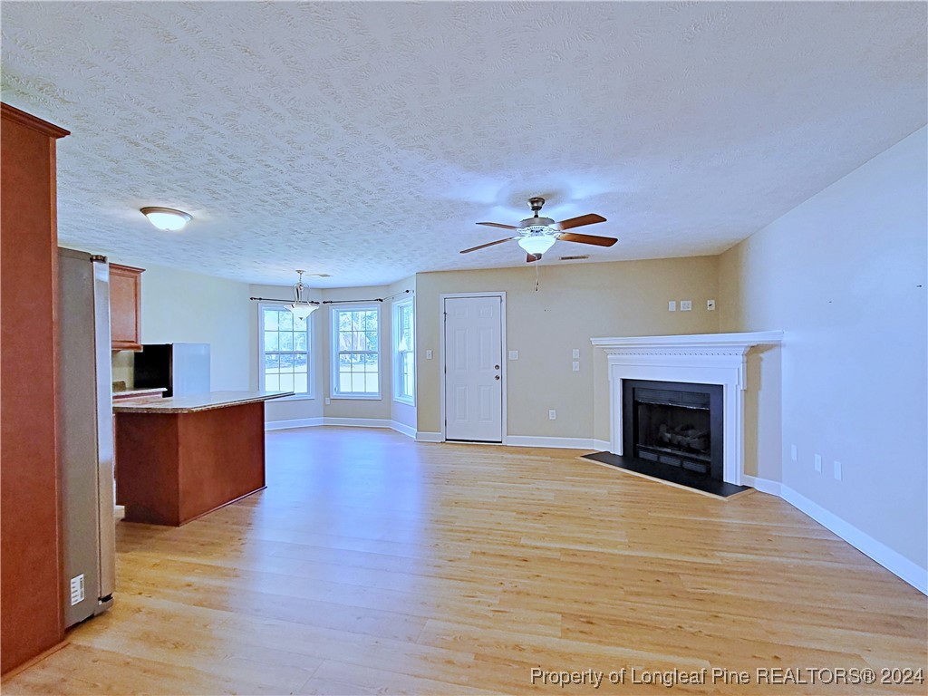 235 Chestnut Drive Raeford, NC 28376 - Photo 11 of 50 a view of a livingroom with a fireplace wooden floor and chandelier