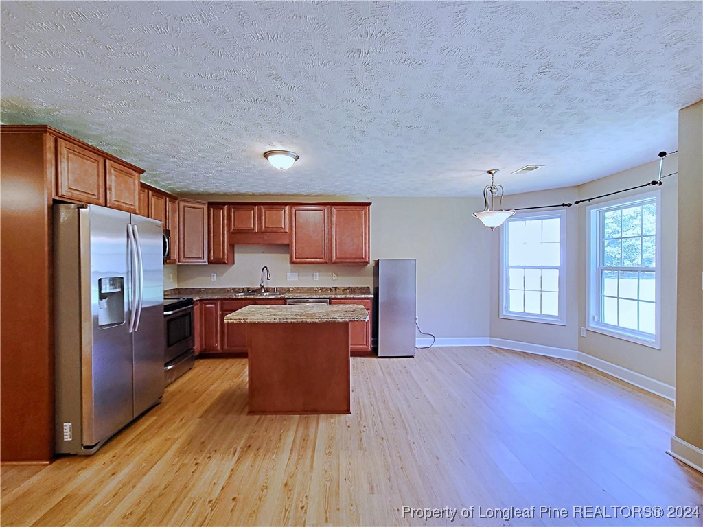 235 Chestnut Drive Raeford, NC 28376 - Photo 13 of 50 a large kitchen with stainless steel appliances granite countertop a stove a refrigerator a sink dishwasher and a oven with wooden floor
